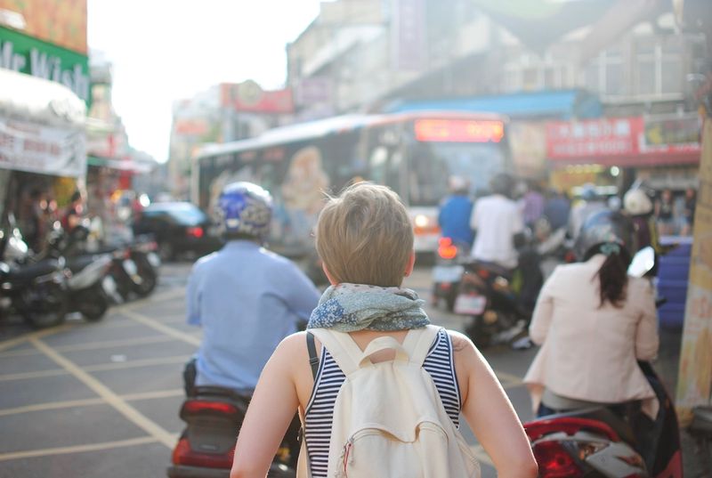 A traveler walking down a busy street